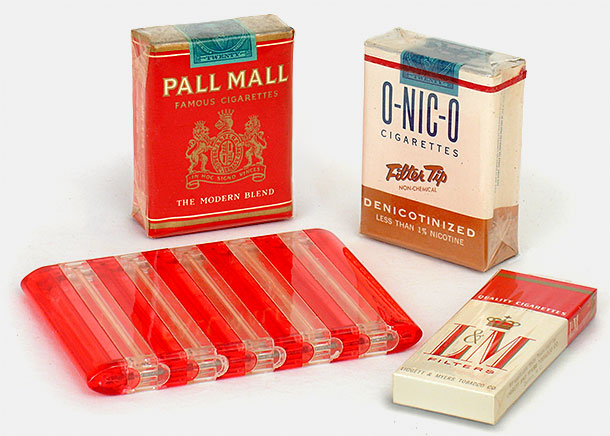 1938 Pall Mall cigarette pack, O-Nic-O 'Denicotinized, non-chemical' cigarettes from 1953,Spring-loaded clear plastic cigarette case, small L&M box is a complimentary pack of four from the 1960s--cigarette companies used to pass out these free packs on street corners out of the goodness of their hearts. From 'More Cigarettes and Smoking' at the web's largest private collection of antiques & collectibles: https://www.ericwrobbel.com/collections/cigarettes-and-smoking.htm
