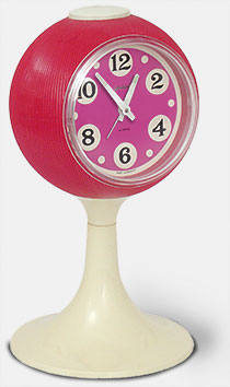 Vintage collectible Goldbühl wind-up alarm clock on a pedastal base in purple and white plastic (c.1967, West Germany). It's about four inches across. From 'A Collection of Clocks' at the web's largest private collection of antiques & collectibles: https://www.ericwrobbel.com/collections/clocks.htm