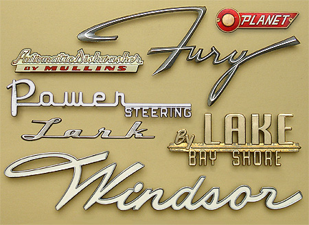 Antique collectible nameplates: Plymouth Fury, Windsor, Impala, Belair, Lark, Power Steering, by Lake Bay Shore, Automatic Dishwasher by Mullins, Planet. Booth/Babylon and By Lake/Bay Shore are car tags applied by dealers to the rear of a car's trunk in some parts of America. From 'More Nameplates and Lettering' at the web's largest private collection of antiques & collectibles: https://www.ericwrobbel.com/collections/nameplates-lettering-2.htm