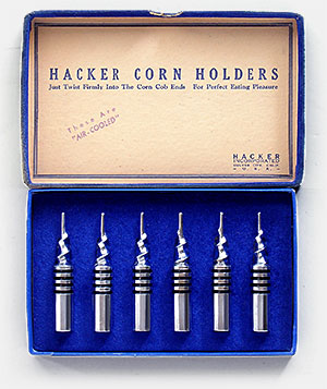 These aren't the little yellow & green plastic dealies you stick in each end of a hot corn cob, these are heavy, metal Air-Cooled Hacker Corn Holders. 'Just twist firmly into the corn cob ends for perfect eating pleasure.' They're from Hacker Inc., Culver City, California, USA. Stamped inside box is: 'These are Air-Cooled.' From 'On the Table, More!' at the web's largest private collection of antiques & collectibles: https://www.ericwrobbel.com/collections/table-2.htm